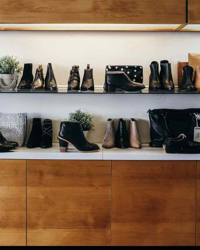 Interior de una zapatería con estanterías de madera y zapatos expuestos